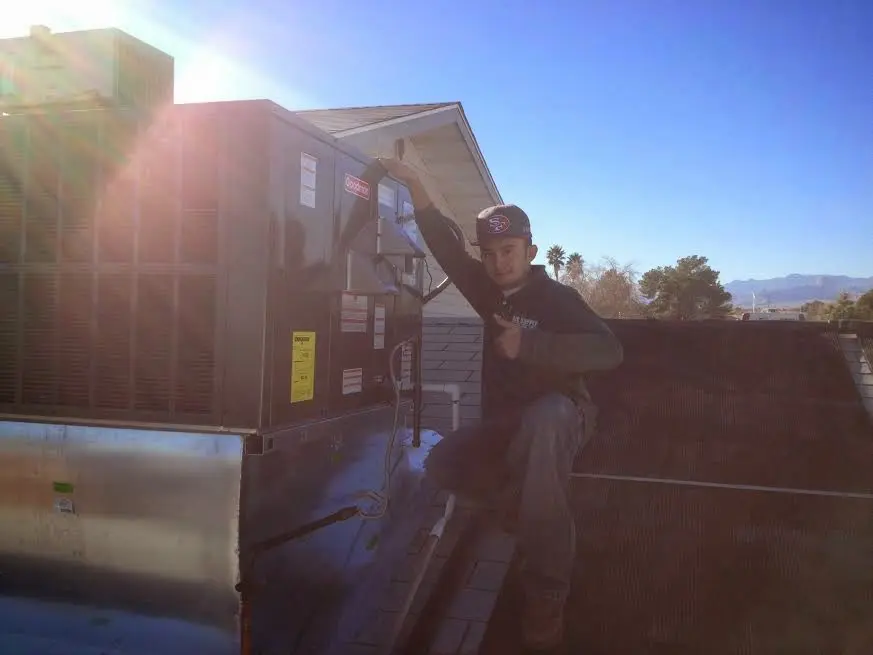 HVAC technician performing AC Tune-Up on a rooftop unit in Elizabethton